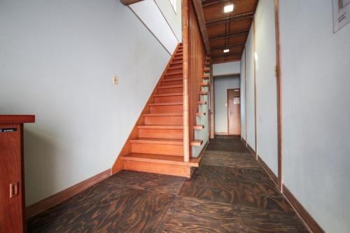 a hallway with wooden stairs in a house at ニューお染 in Kotohira