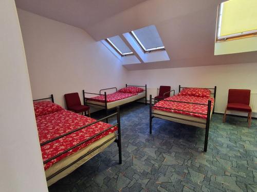 a room with four beds with red sheets and windows at Jugata in Rudna Wielka