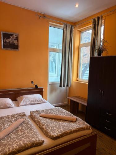 ein Schlafzimmer mit einem Bett und einem Fenster in der Unterkunft Elegance on a Budget - Rooms for Rent in Sofia Center in Sofia