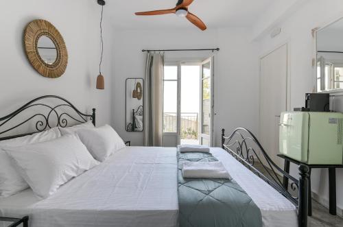 a bedroom with a large bed with a ceiling fan at Tepeleni, Parga Apts with Pool in Agiá