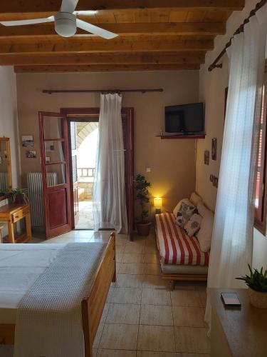a bedroom with a bed and a couch and a tv at Almyra apt in Mani in Kotrónion