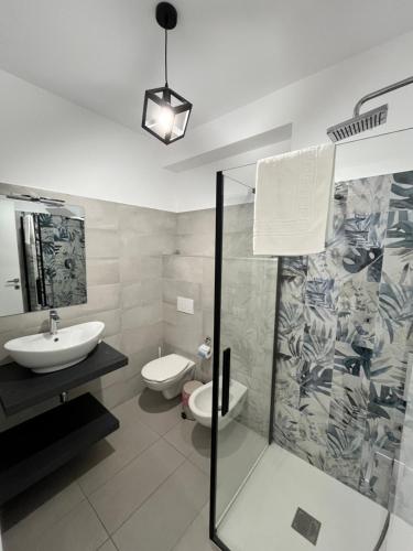 a bathroom with a shower and a sink and a toilet at La Maison de Marcelle in Tropea