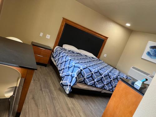 a bedroom with a bed with a blue comforter at Bragg Motel in Upper Marlboro