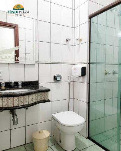 a bathroom with a toilet and a sink at Fênix Plaza Hotel in Aquidauana