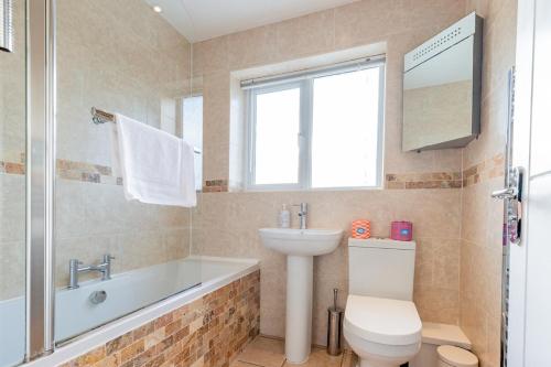 a bathroom with a sink and a toilet and a bath tub at Drovers Way, Worcester in Fernhill Heath
