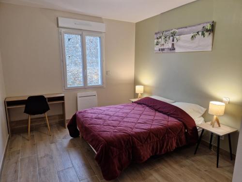 a bedroom with a bed with a purple comforter at La maison du Lac in Louin