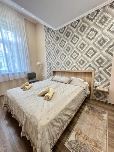 a bedroom with a bed with two towels on it at Gesztenye Apartman in Makó