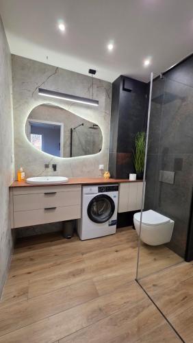 a bathroom with a washing machine and a sink at Wyspa9 - Gdańsk Wyspa Sobieszewska in Gdańsk