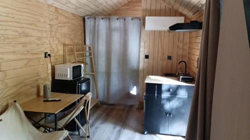 a small room with a table and a microwave at Bungalows y Glamping Medina Sidonia in Medina Sidonia