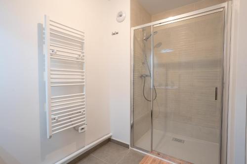 a shower in a bathroom with a glass shower stall at L'Escale d'Erdeven - En centre-bourg in Erdeven