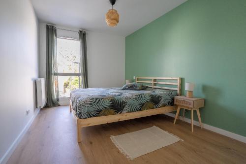 a bedroom with a bed and a green wall at L'Escale d'Erdeven - En centre-bourg in Erdeven