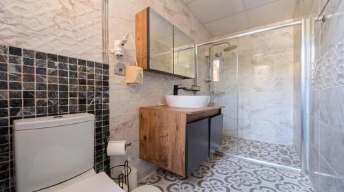 a bathroom with a toilet and a sink and a shower at Stone House Foça Otel in Yenifoça