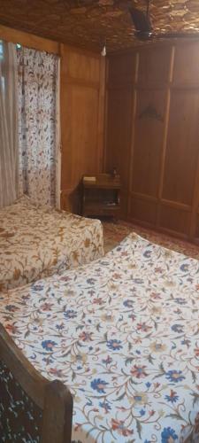 ein Schlafzimmer mit zwei Betten und einer geblümten Bettdecke in der Unterkunft Mashal in Srinagar