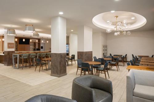 a restaurant with tables and chairs and a bar at EVEN Hotel Chicago - Tinley Park - Convention Center by IHG in Tinley Park