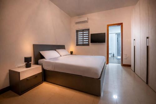 a bedroom with a large bed and a television at Modern SeaView Luxury Apartment in St. Paul's Bay