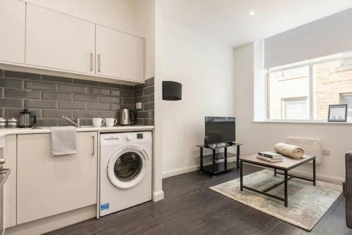 a kitchen with a washing machine and a table at Cosy 1 Bedroom Apartment in Bradford in Bradford