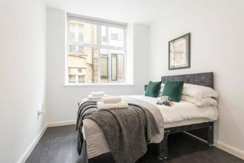 a bedroom with a bed with green pillows and a window at Cosy 1 Bedroom Apartment in Bradford in Bradford