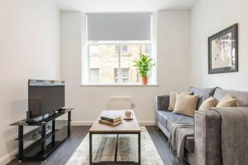 a living room with a couch and a tv at Cosy 1 Bedroom Apartment in Bradford in Bradford