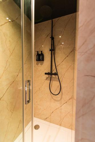a shower with a glass door with a camera in it at Tiny boat house #2 in Garnwerd