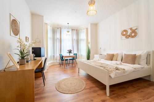 a white bedroom with a desk and a bed in a room at Celine Prague Luxury Hostel in Prague