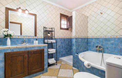 a blue tiled bathroom with a tub and a sink at Villa La Colina in Torrox