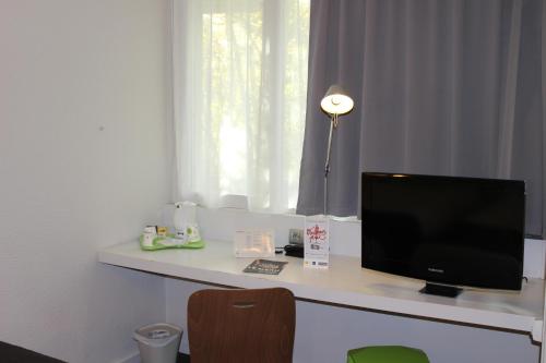 a desk with a computer monitor on top of it at Campanile Toulon - La Seyne sur Mer - Sanary in Six-Fours-les-Plages