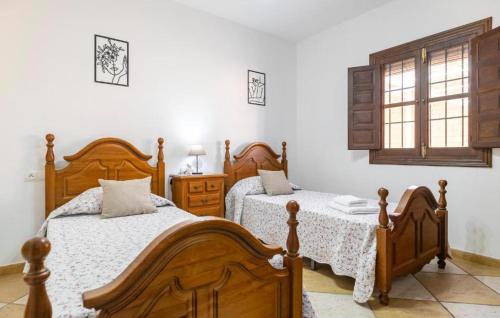 a bedroom with two beds and a window at Villa La Colina in Torrox