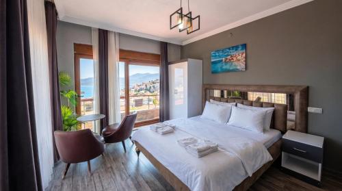 a bedroom with a bed and a large window at Stone House Foça Otel in Yenifoça