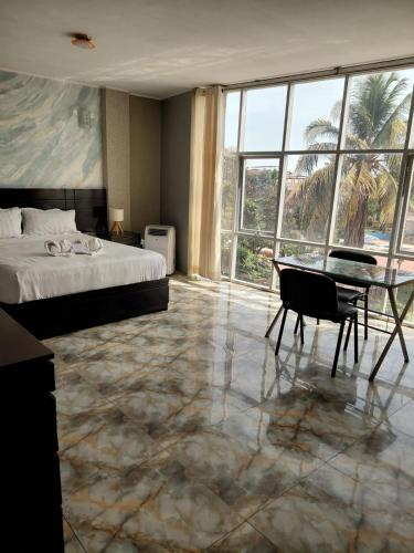 a bedroom with a bed and a desk and a table at Hotel Emmanuel in Chepén
