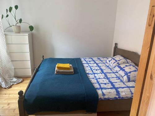 a bedroom with a blue bed with a towel on it at St Johns sunny side apartment in Cēsis