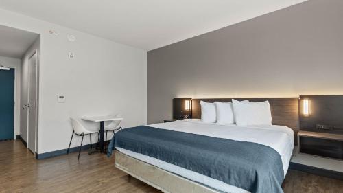 a hotel room with a large bed and a table at Studio 6 Richmond Airport in Sandston
