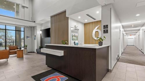 an office lobby with a reception desk and a hallway at Studio 6 Richmond Airport in Sandston