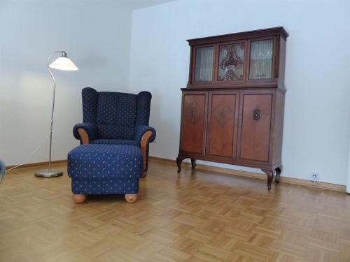 a living room with a chair and a cabinet at Ferienwohnung Asenberg in Bad Salzuflen
