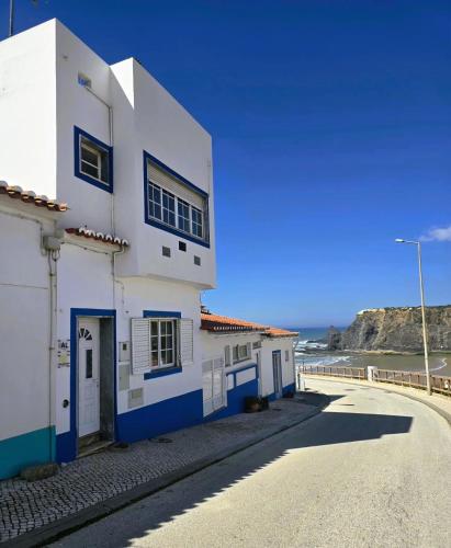 a white and blue building on the side of a road at Sol da Praia in Odeceixe