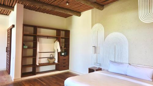 a bedroom with a bed and a book shelf at Zahari Oceanfront in Msambweni