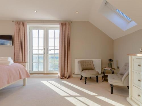 a bedroom with a bed and two chairs and a window at 3 Bed in Stokesley oc-77667 in Carlton