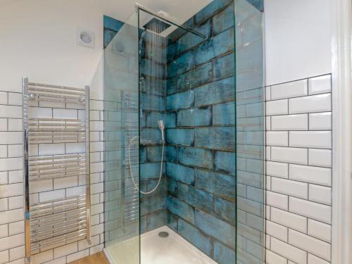 a bathroom with a shower with blue tiles at 3 Bed in Stokesley oc-77667 in Carlton