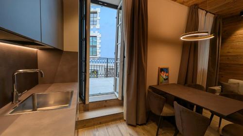 a kitchen and dining room with a table and a window at Isolden Green Srl Berlanda Mountain suites in Cavalese
