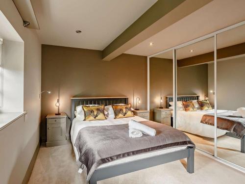 a bedroom with two beds and a large mirror at 5 Bed in Leeds oc-91355 in Sherburn in Elmet