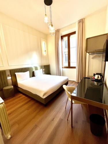 a hotel room with a bed and a desk at Hotel Duca D'Aosta in Florence