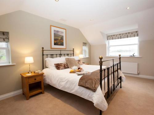 a bedroom with a large bed and two windows at 2 Bed in Stokesley oc-g0072 in Carlton