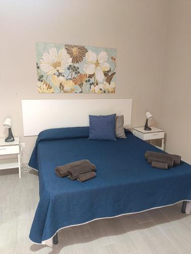 a bedroom with a blue bed with towels on it at Il Sole del Mediterraneo in Noto