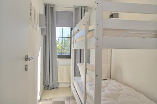 a room with two bunk beds and a window at Haus Titania App 6 inkl WLAN in Grömitz