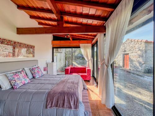 a bedroom with a bed and a large window at Casa Largo do Porto - Country House with Swimming Pool in Viana do Castelo