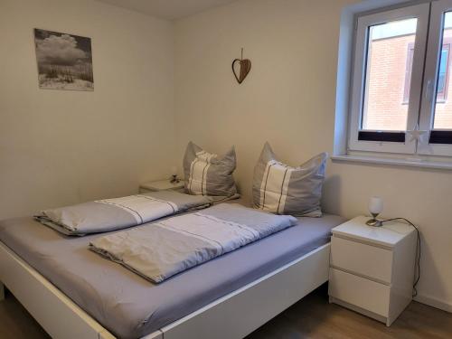 a bed with two pillows on it in a room at Ferienwohnung "Strandläufer 1" in Böhl
