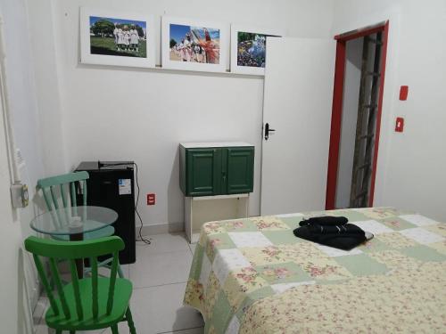a room with a table and a green chair at Estalagem Triplex Vermelho in Vitória