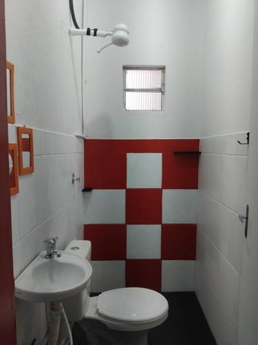 a bathroom with a toilet and a sink at Estalagem Triplex Vermelho in Vitória