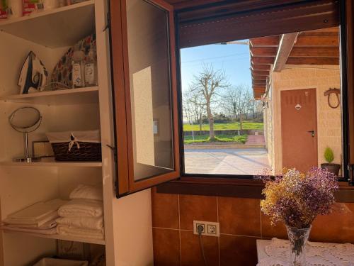 a window in a room with a vase of flowers at Refugio y Calma in Chantada