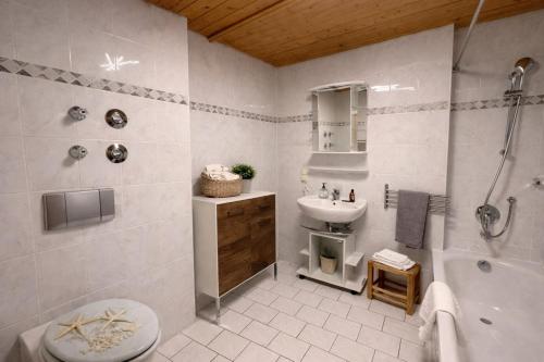 a bathroom with a sink and a toilet and a shower at Ferienwohnung Forggensee-Blick in Schwangau