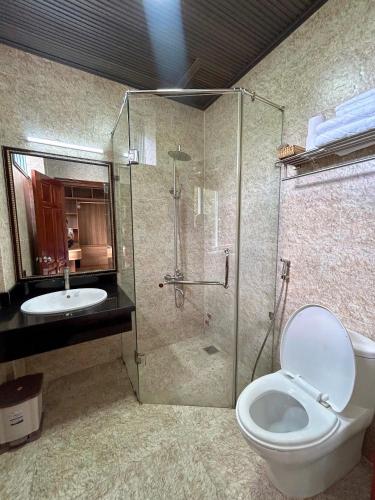 a bathroom with a shower and a toilet and a sink at Twins Villa Đà Lạt in Khu Chi Lăng